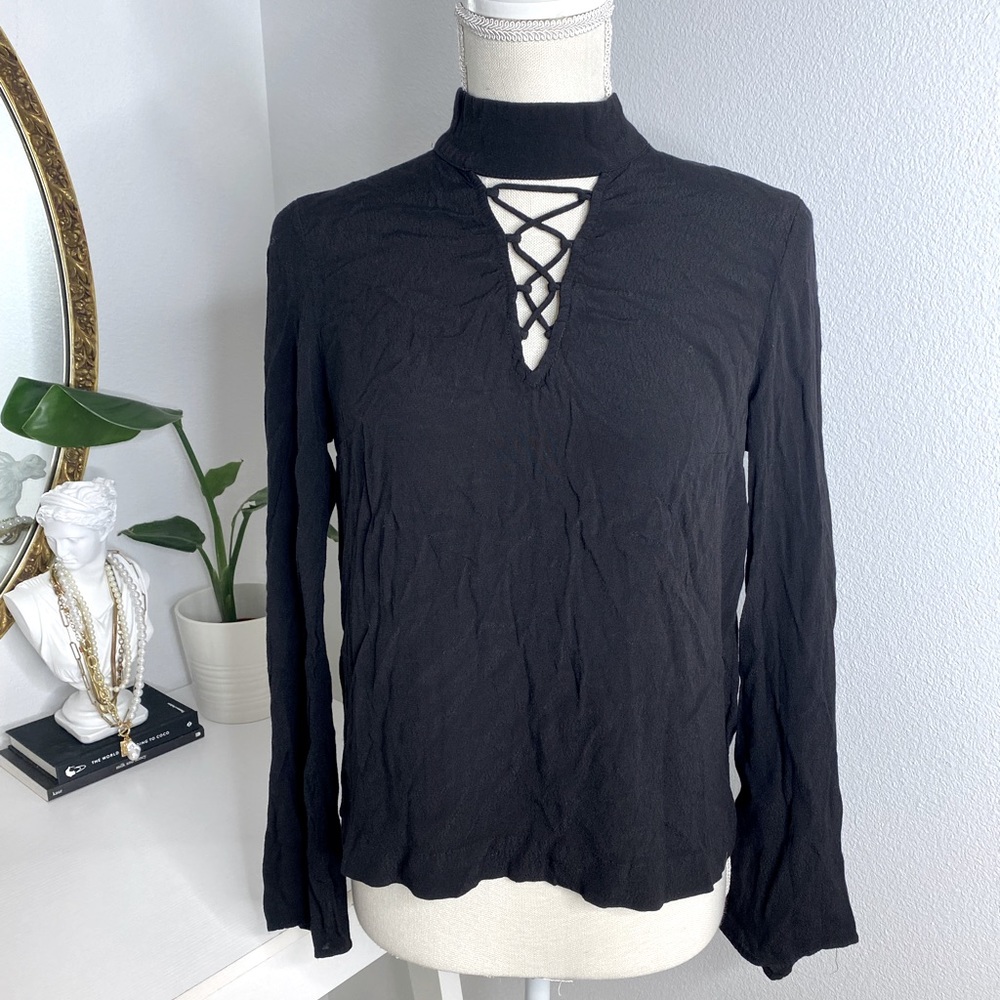 Black long sleeve blouse with cross cross design across chest
